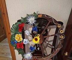 Wooden cartwheel with lovely flowers with mini garden tools